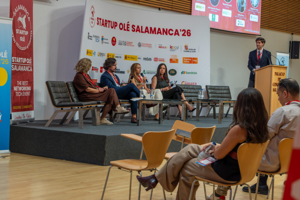 Mesa redonda en Startup OLÉ Salamanca’26, en el Palacio de Congresos, con cuatro ponentes sentados en el escenario y un moderador en el atril.